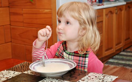 Ребенок ест молочную кашу