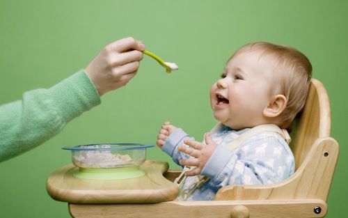 Ребенка кормят из ложки