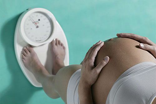 Беременная измеряет вес