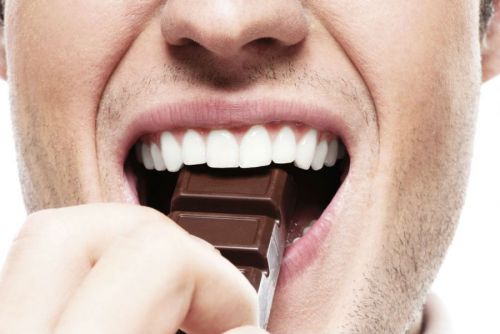 Мужчина ест шоколад