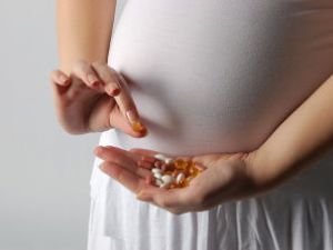 Беременная с таблетками в руках